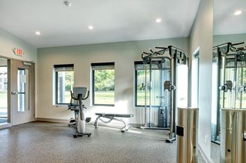 A gym with a treadmill, elliptical machines, and other exercise equipment.